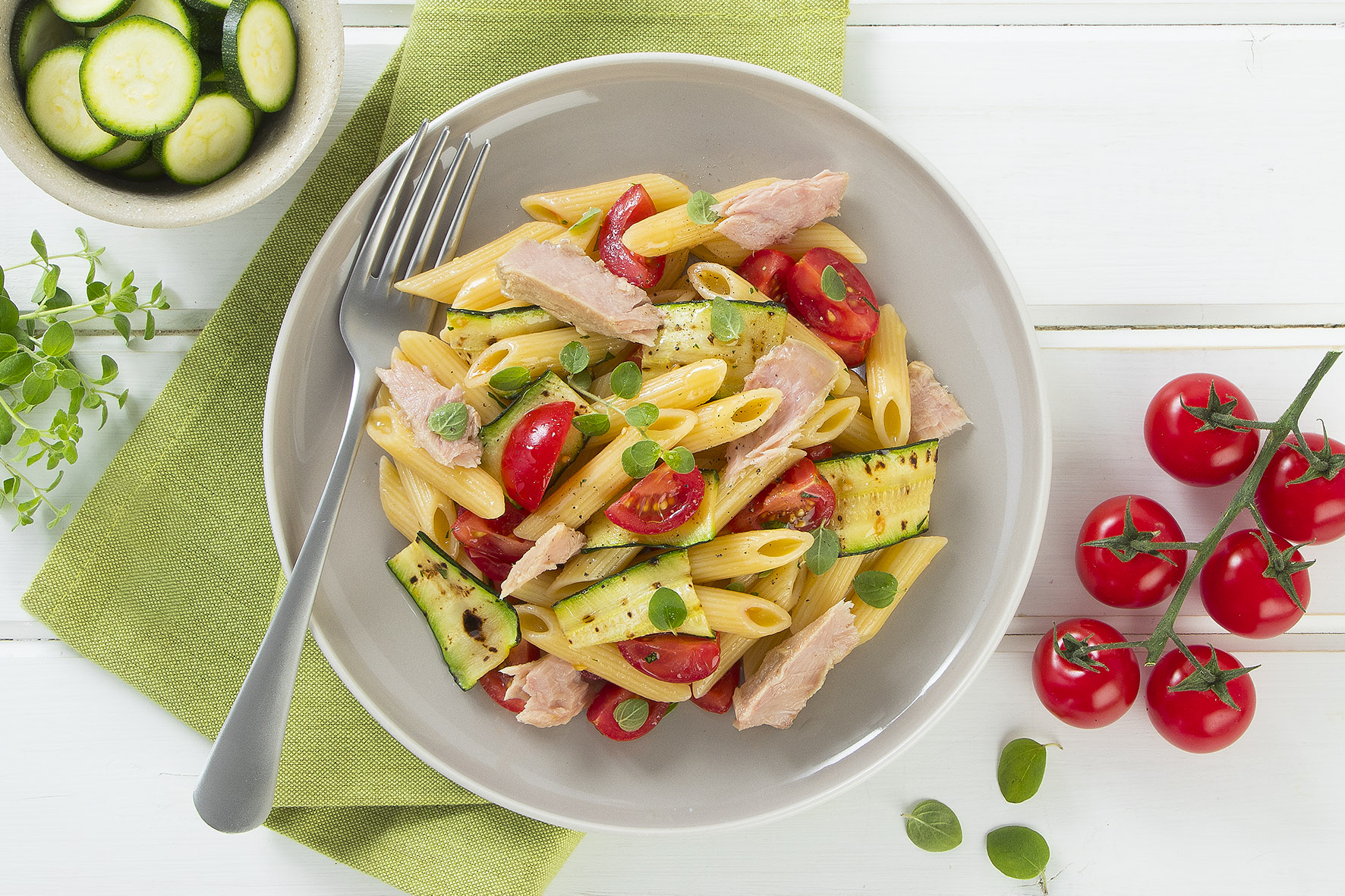 Penne con tonno, zucchine, pomodori ed erbe aromatiche